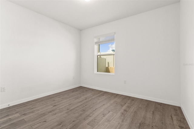 unfurnished room with baseboards and wood finished floors