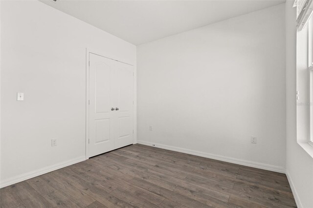 unfurnished room featuring dark wood-type flooring