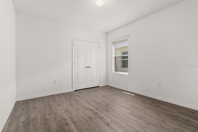 empty room featuring wood finished floors and baseboards