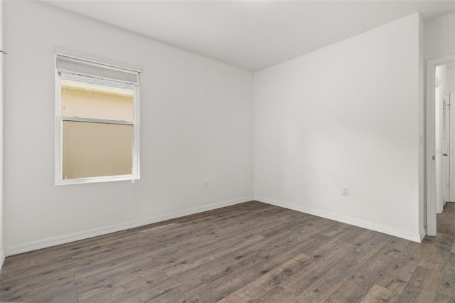 unfurnished room with baseboards and wood finished floors