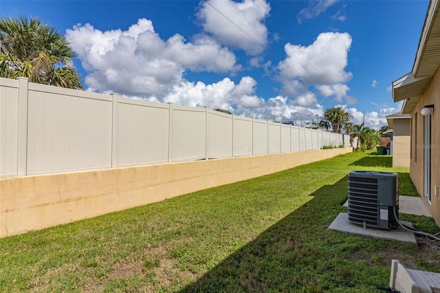 view of yard featuring central AC unit and fence