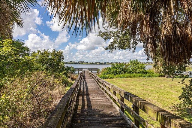 view of dock featuring a lawn and a water view