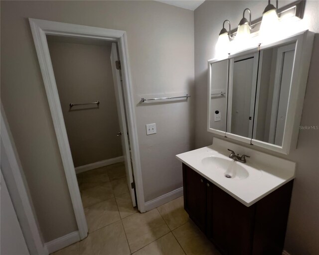 bathroom featuring tile patterned flooring, vanity, and baseboards