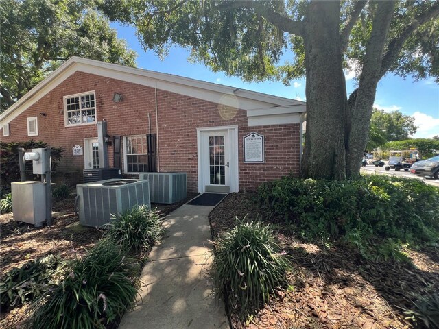 view of front of home featuring brick siding and central air condition unit