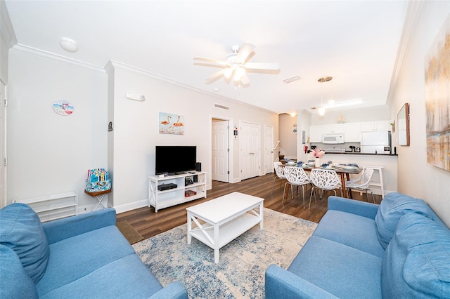 living room featuring dark wood-type flooring, ceiling fan, and crown molding