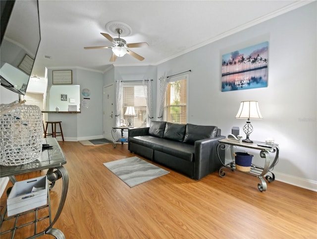 living room featuring ornamental molding, light hardwood / wood-style flooring, and ceiling fan