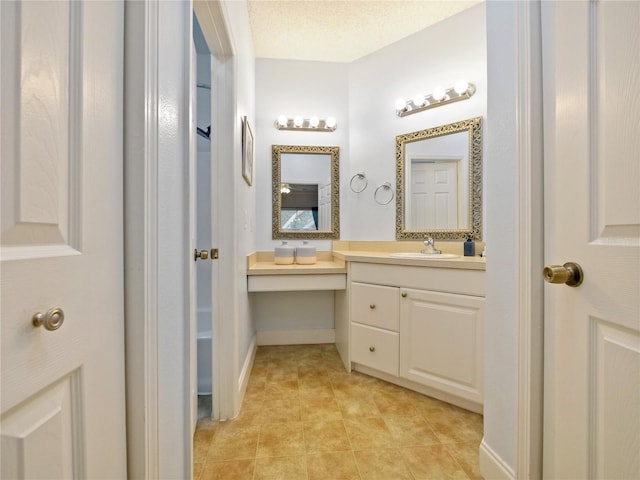 bathroom with tile patterned floors, a textured ceiling, and vanity