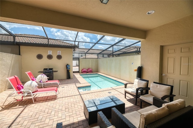 view of swimming pool with grilling area, glass enclosure, outdoor lounge area, and a patio