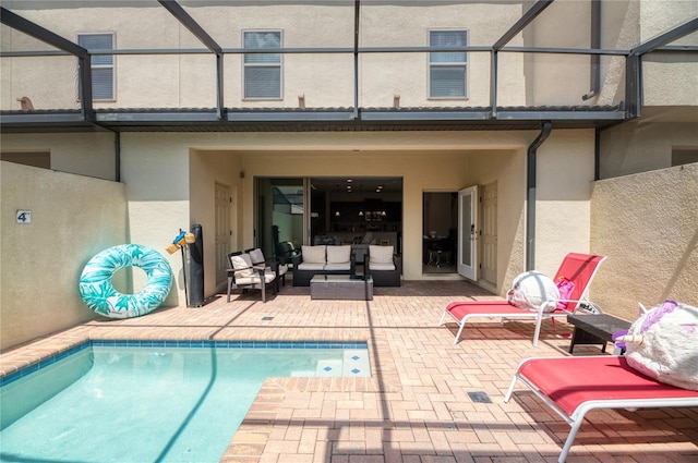 view of pool with glass enclosure and a patio