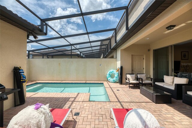 view of swimming pool with outdoor lounge area, a lanai, and a patio area