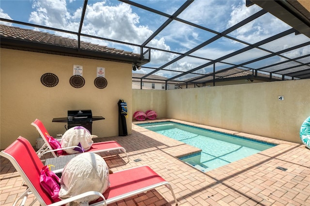 view of swimming pool featuring a lanai and a patio