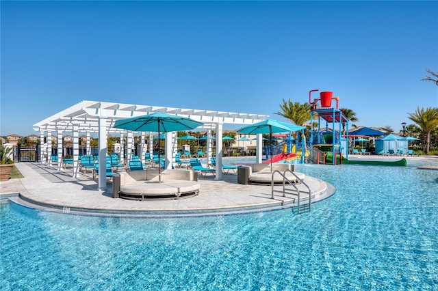 view of pool with a water slide and a pergola