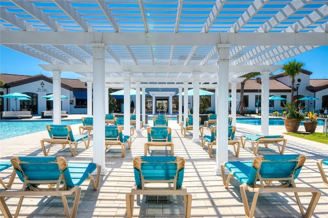 view of patio featuring a community pool and a pergola