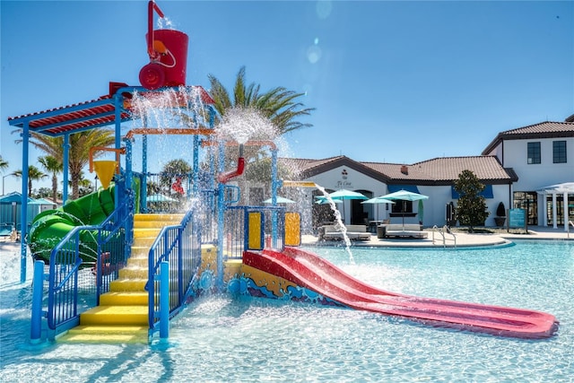 view of swimming pool featuring pool water feature, a water slide, and a patio area