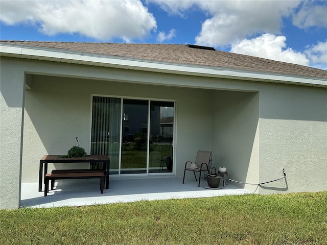 back of property featuring a patio area and a lawn