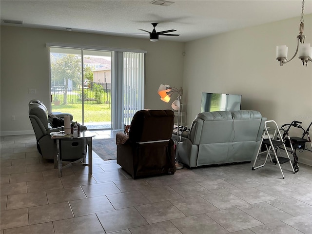 living area with visible vents, baseboards, and ceiling fan with notable chandelier