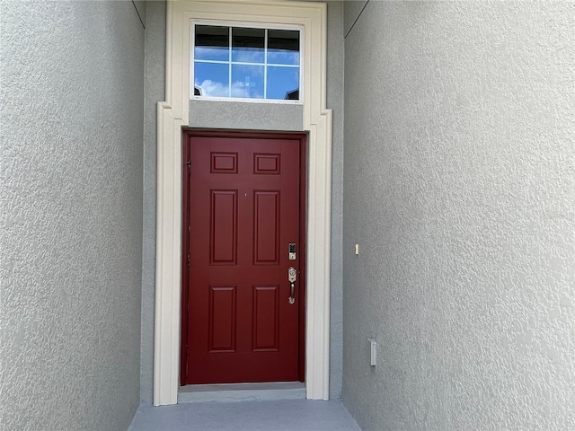 view of exterior entry with stucco siding