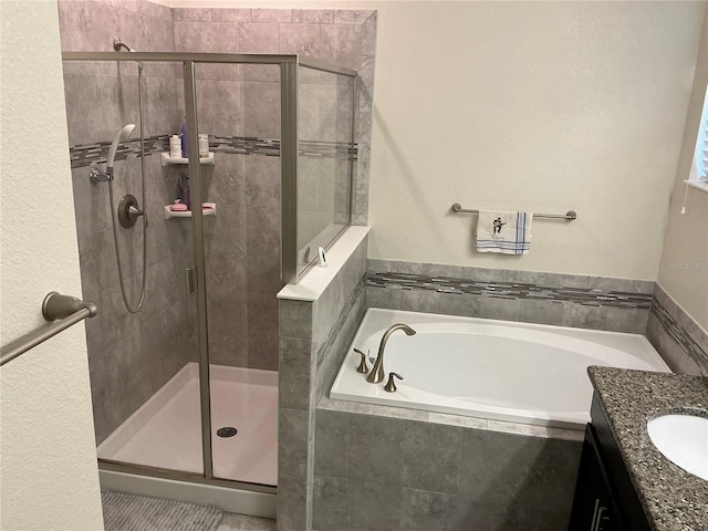 bathroom with a stall shower, a garden tub, and vanity