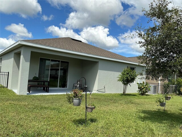 rear view of property with a yard and a patio