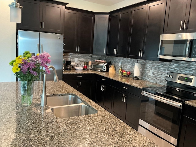 4183 Cortland Dr, Davenport, FL 33837 - kitchen with a sink, backsplash, stainless steel appliances, and dark stone countertops