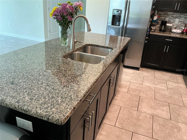4183 Cortland Dr, Davenport, FL 33837 - kitchen featuring a kitchen island with sink, dark cabinets, a sink, and stainless steel fridge with ice dispenser