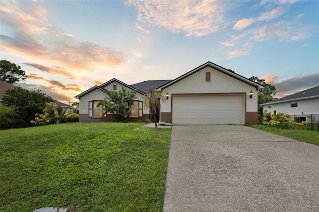 ranch-style home with a garage and a yard