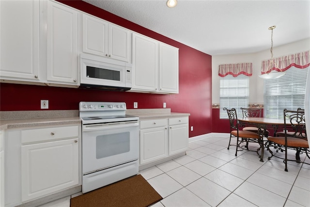 kitchen featuring white appliances, white cabinets, light countertops, pendant lighting, and light tile patterned flooring