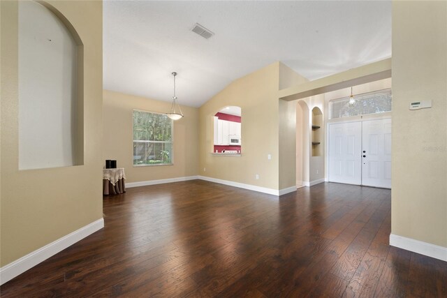 spare room featuring vaulted ceiling and dark hardwood / wood-style floors