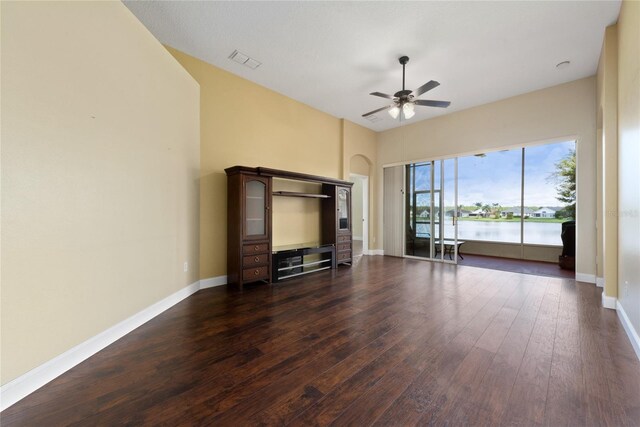 unfurnished living room featuring dark wood-type flooring and ceiling fan