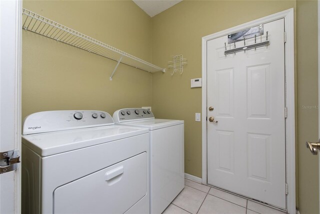 washroom featuring washer and dryer and light tile patterned flooring