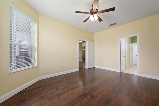 unfurnished bedroom featuring a ceiling fan, baseboards, visible vents, and wood finished floors