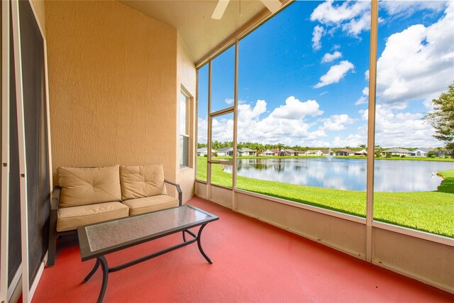 sunroom / solarium with a water view and ceiling fan