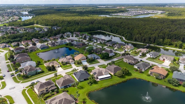 drone / aerial view featuring a residential view, a water view, and a wooded view