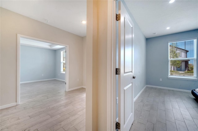 hall featuring light wood-style floors and baseboards