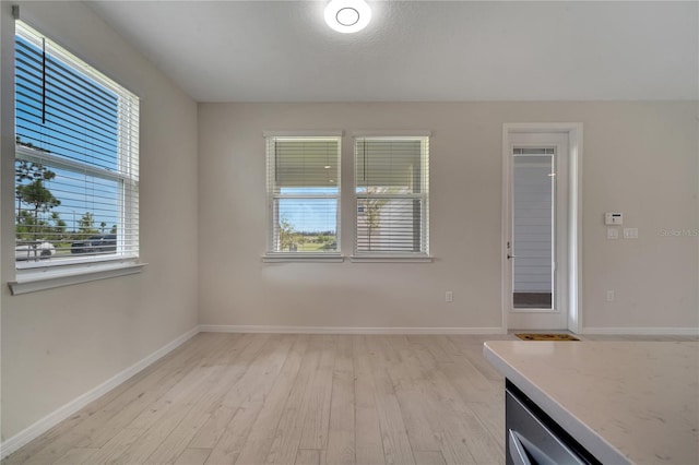 unfurnished room featuring light wood finished floors and baseboards