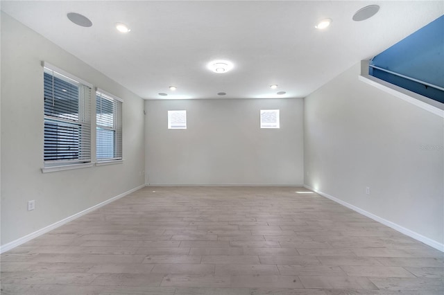 empty room with light wood-style floors, recessed lighting, and baseboards