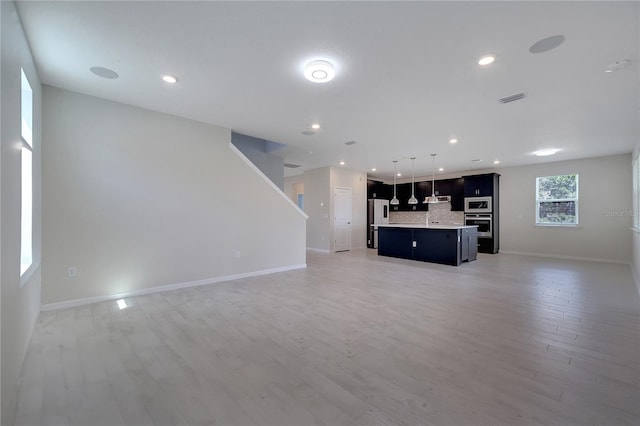 unfurnished living room with light wood-style floors, recessed lighting, visible vents, and baseboards