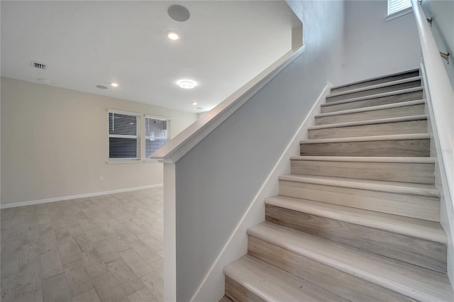 stairs featuring baseboards, visible vents, wood finished floors, and recessed lighting