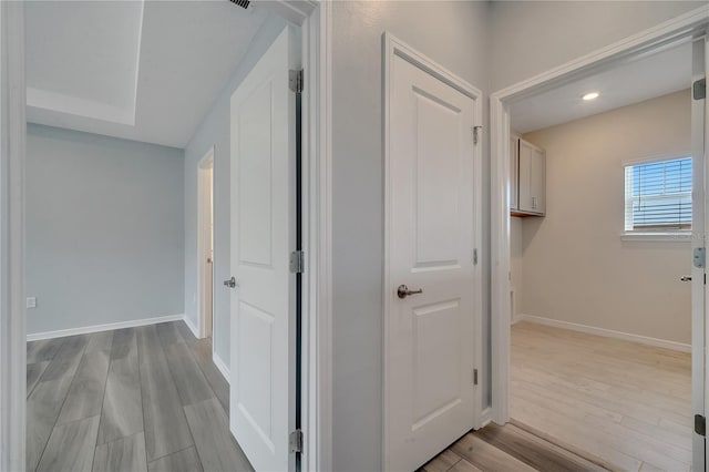 hall with baseboards and light wood-style floors