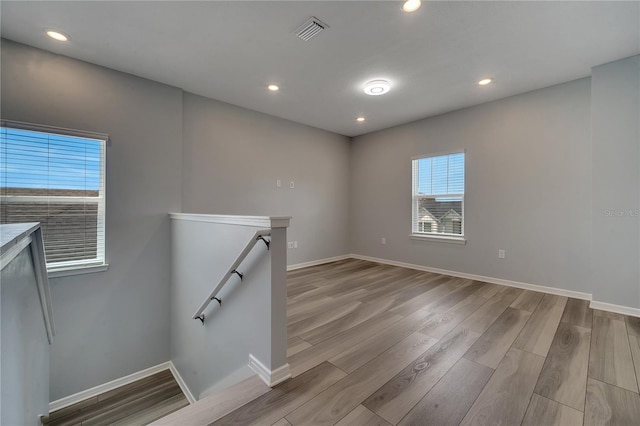 spare room with recessed lighting, wood finished floors, visible vents, and baseboards