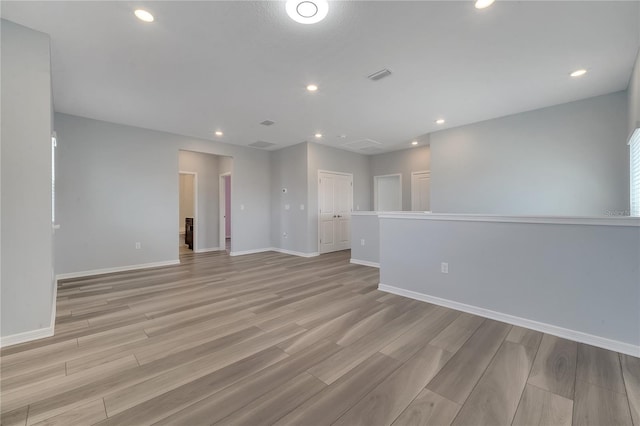 unfurnished room with light wood-style floors, baseboards, visible vents, and recessed lighting