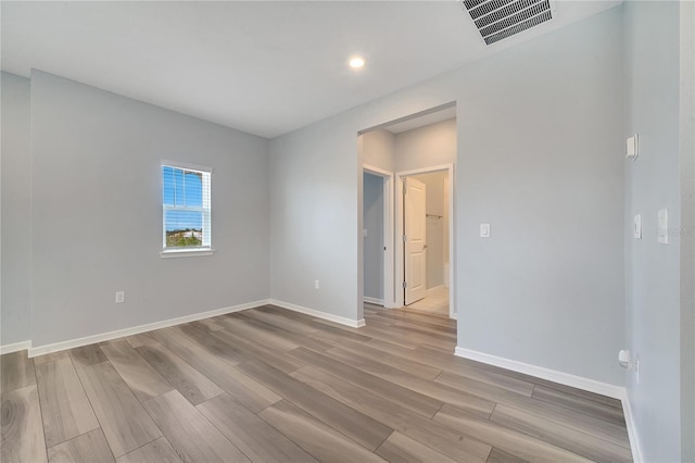 unfurnished room with recessed lighting, visible vents, baseboards, and wood finished floors