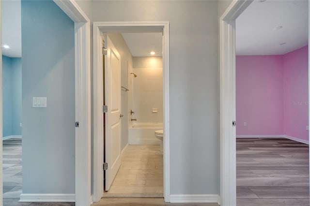 hall featuring baseboards and wood finished floors