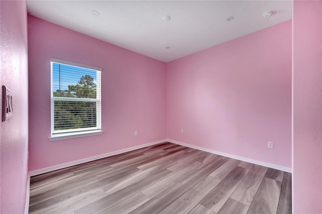 unfurnished room with baseboards and wood finished floors