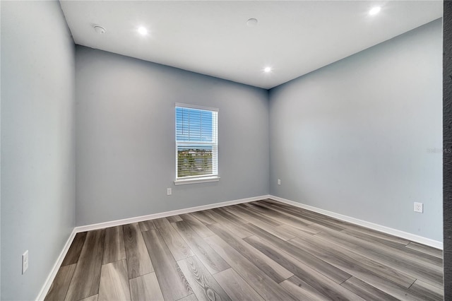 empty room featuring recessed lighting, baseboards, and wood finished floors