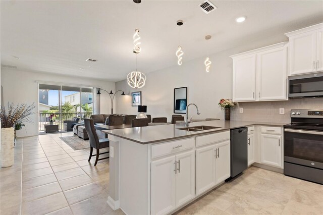 kitchen featuring hanging light fixtures, stainless steel appliances, sink, kitchen peninsula, and white cabinets