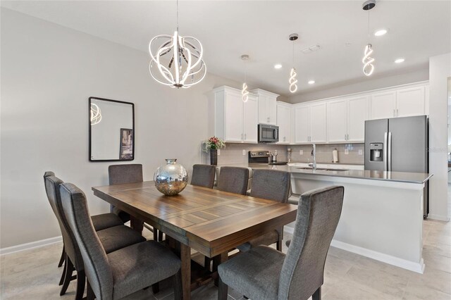 dining space featuring sink and an inviting chandelier