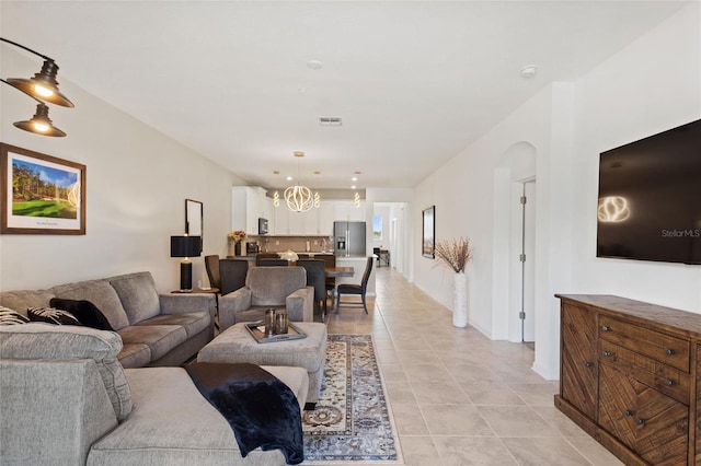 tiled living room featuring a chandelier