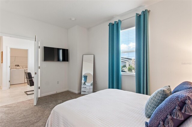 carpeted bedroom with washing machine and dryer