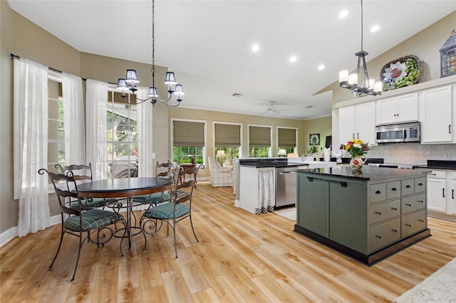 kitchen featuring ceiling fan with notable chandelier, appliances with stainless steel finishes, light hardwood / wood-style floors, a center island, and white cabinets